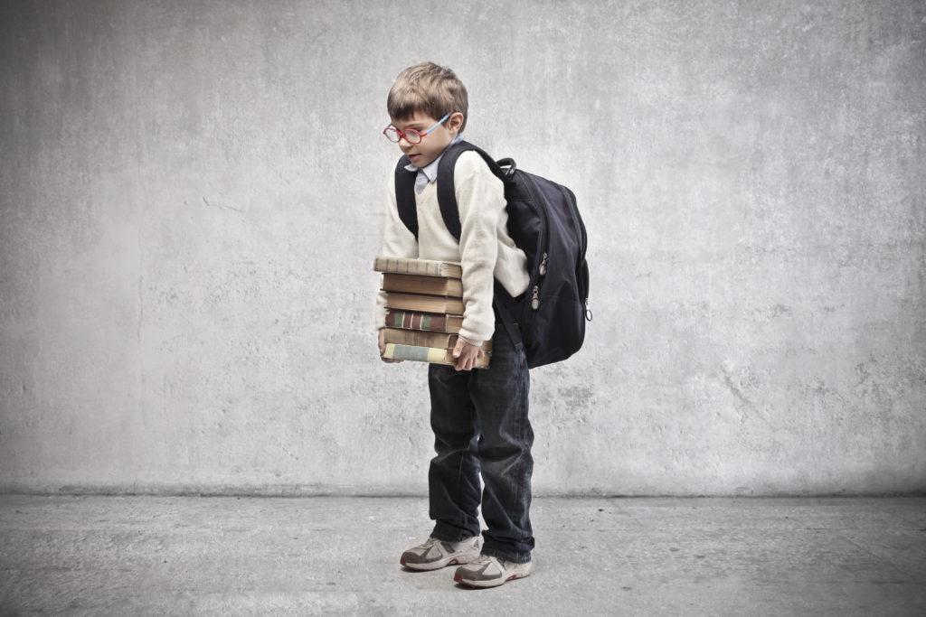 young child with heavy backpack