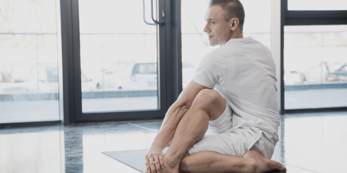 Young man stretching for back pain relief.